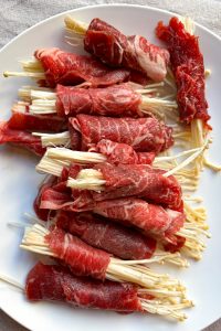 Wrap the enoki mushrooms with sliced beef